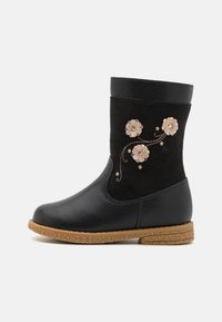 Czarny botek do połowy łydki z brązową podeszwą, zdobiony trzema beżowymi aplikacjami w kształcie kwiatów oraz haftem w vine na cholewie.