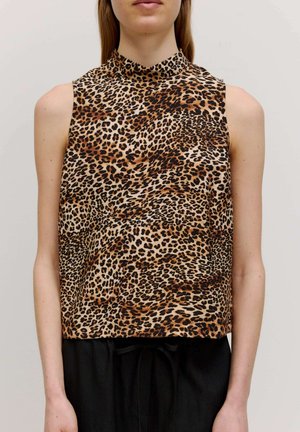 Ärmelloses Top mit Leopardenmuster und hohem Kragen, mit glatter Textur, beigem Grund und schwarzen sowie braunen Flecken. Kombiniert mit schwarzen Hosen.