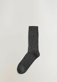 Sosete negre cu textură, de înălțime medie până la gambe, cu vârf rotund. Prezentând un detaliu cu o mică gaură aproape de gleznă.