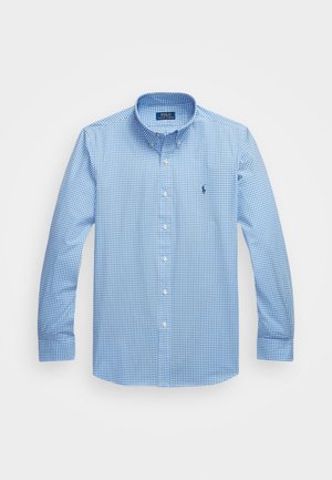 Camisa azul e branca de xadrez, com botões, mangas longas, tecido de algodão, colarinho clássico, apresentando um pequeno logotipo no lado esquerdo do peito.