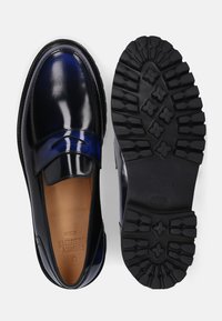 Mocassini in pelle verniciata blu navy con una fascia decorativa; fodera in pelle color cuoio; suola in gomma nera con battistrada testurizzato; marchio sulla soletta.