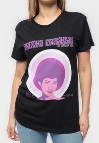 Black cotton t-shirt featuring a colorful graphic of a woman's face, surrounded by concentric circles in pink and white, with text.