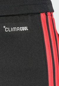 Čierne športové šortky s červenými bočnými pruhmi a logom „CLIMACOOL“. Vyrobené z textúrovaného materiálu pre priedušnosť a pohodlie.