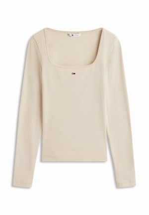 Beige ribbel top met lange mouwen, vierkante halslijn en klein Tommy Jeans vlaglogo gecentreerd onder de kraag.