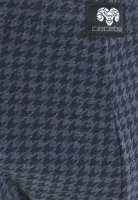 Marineblauwe broeken met een houndstooth-patroon in donkergrijs. Gemaakt van zachte stof, met een zak en een klein merklogo.