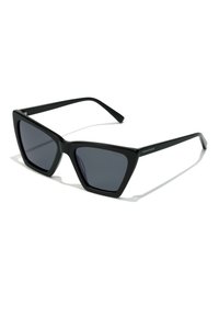 Black sunglasses with a geometric cat-eye design, featuring dark lenses and matte plastic frames. Minimalist branding on the side.