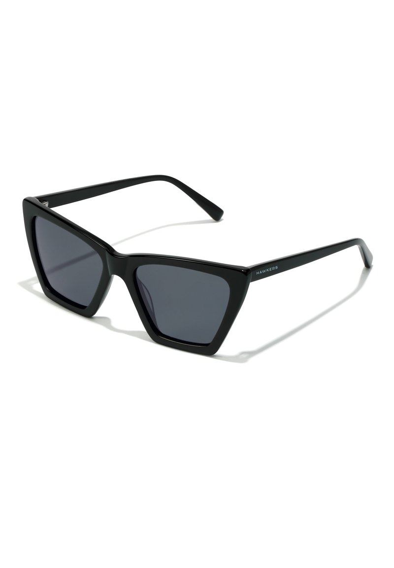 Black sunglasses with a geometric cat-eye design, featuring dark lenses and matte plastic frames. Minimalist branding on the side.
