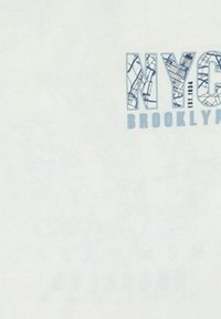Camiseta blanca con gráfico en azul que dice "NYC" y "BROOKLYN" con un diseño en patrón que recuerda a un mapa de la ciudad. Textura suave y ligera.