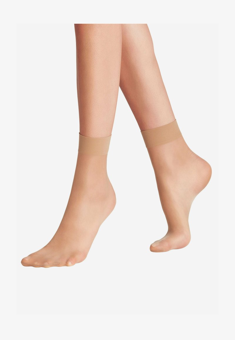 Chaussettes chevilles nude transparentes avec un revers doux et élastique. Texture lisse avec un matériau léger et respirant. Conception à bout ouvert pour le confort.