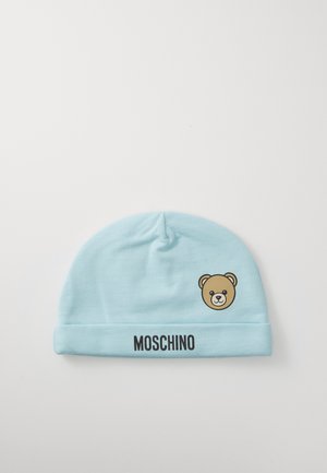 Hellblaues Babymütze mit Teddybär-Gesichtsgrafik und "MOSCHINO"-Text auf dem umgeschlagenen Saum, flach auf einem weißen Hintergrund ausgelegt.