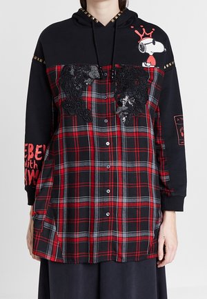 Camisa de cuadros negra y roja con botones, aplicación de encaje negro, capucha negra con tachuelas doradas, Snoopy con una corona roja en el pecho y texto rojo en la manga.