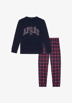Granatowy zestaw piżamowy z długim rękawem, z białym i czerwonym napisem "APRÈS SKI" oraz spodniami w kratkę w czerwone, granatowe i niebieskie wzory.