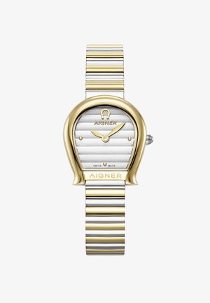 Kultakello ja hopeanvärinen kello, jossa on ainutlaatuinen ovaalinen kotelo, teksturoitu hopeinen kellotaulu ja raidallinen metalliranneke. Kello sisältää Aigner-brändäyksen ja sveitsiläisen koneiston.