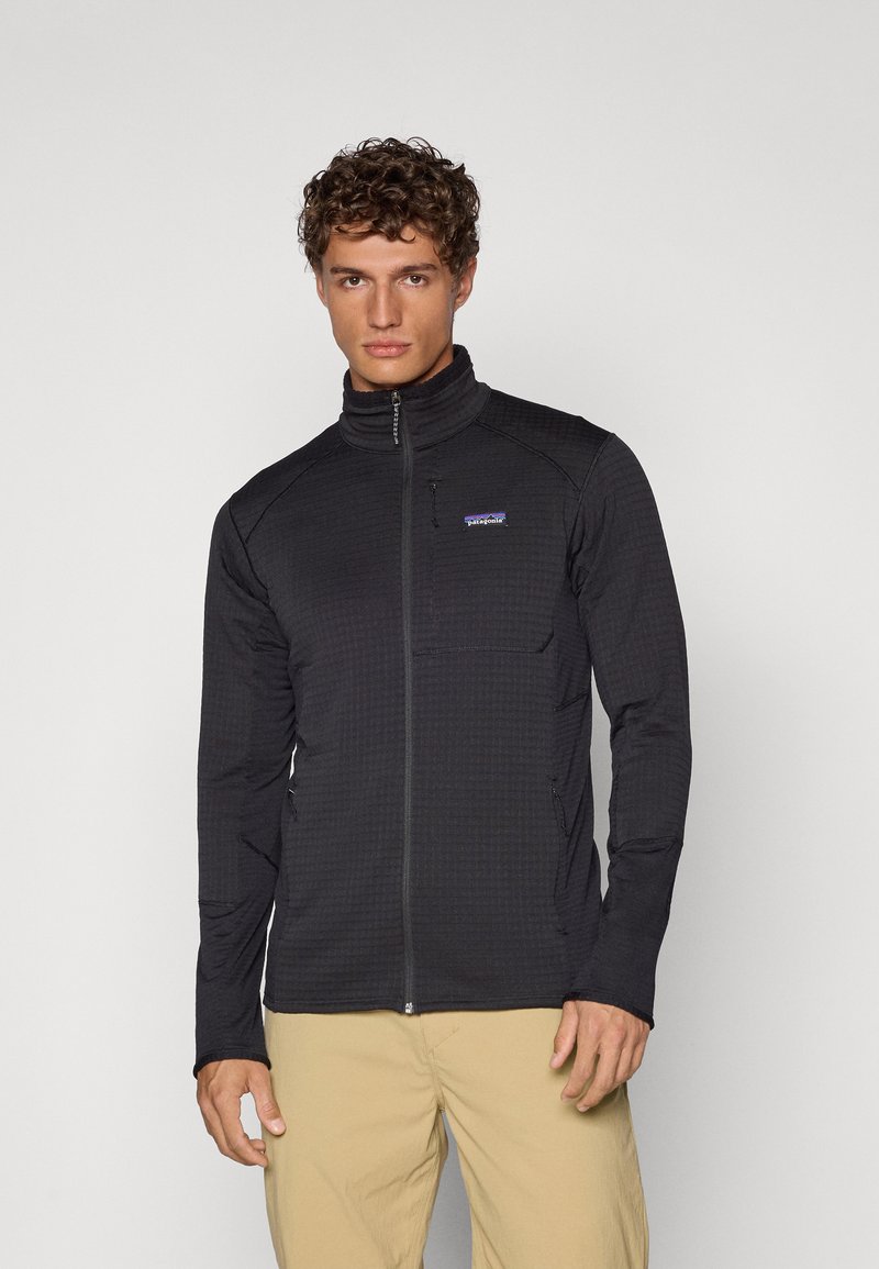 Black zip-up jacket featuring a textured surface, high collar, and side pockets, made from lightweight and breathable material.