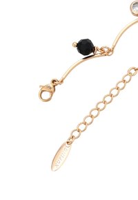 Collana in oro con una perla ottagonale nera e una gemma rotonda trasparente. Presenta una chiusura a moschettone e un'etichetta incisa.