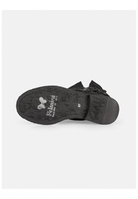 Suela de zapato negra con patrón texturizado, con un tacón bajo y logo en relieve. Incluye detalles de tamaño impresos en la plantilla.
