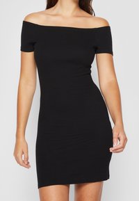 Czarna, dopasowana sukienka bez ramiączek z rozciągliwego materiału, z krótkimi rękawami i długością do połowy uda. Gładka faktura.