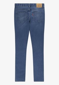 Modré džíny skinny s středně vysokým pasem, pěti kapsami a koženou značkovou nášivkou na zadním pasu.