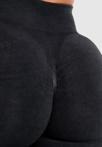Leggings neri senza cuciture con un tessuto morbido ed elastico, dettagli a costine e una vita alta progettata per comfort e supporto.