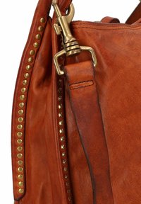 Leren handtas in oranje-bruin met een gladde textuur en gouden studs langs de zijkant. Voorzien van een stevige gouden sluiting en band.