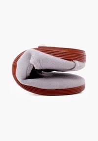 Grijze canvas schoen met een ronde, flexibele, bruine rubberen zool, met een gevouwen ontwerp en een gestructureerd bovenoppervlak.
