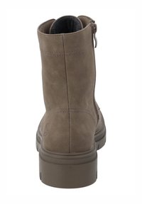 Bottine marron en daim texturé, fermeture éclair sur le côté et semelle épaisse en caoutchouc. Bout arrondi et détails de couture renforcée.