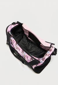 Sac de voyage noir et rose avec des motifs géométriques, extérieur en tissu et un intérieur spacieux noir. Dispose de deux poignées et d'une fermeture éclair.