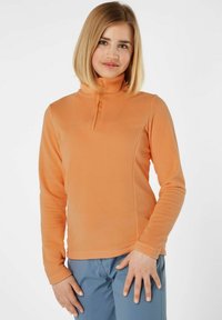 Pullover in pile arancione con collo alto con zip, maniche lunghe e tessuto testurizzato. Presenta un design con pannelli laterali per un look aderente.