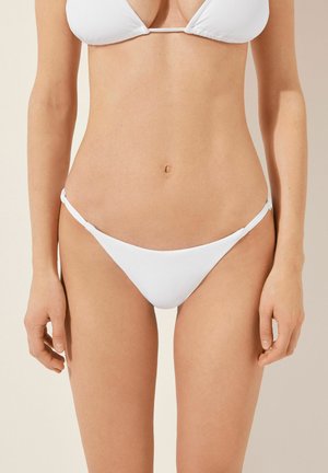 Vitt bikini-set med en triangulär topp och minimal täckning på botten. Slät tyg med knytningar på sidorna av bikiniunderdelen.