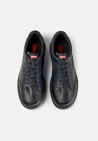 Black leather sneakers with rounded toes, textured surface, flat laces, and red "Camper" logo at the tongue and insole.