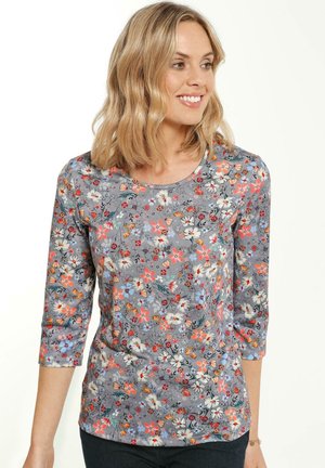 Langärmliges graues Oberteil mit einem floralen Muster, das orange, blaue und weiße Blumen zeigt. Weicher Stoff mit Rundhalsausschnitt und schmalen Ärmeln.