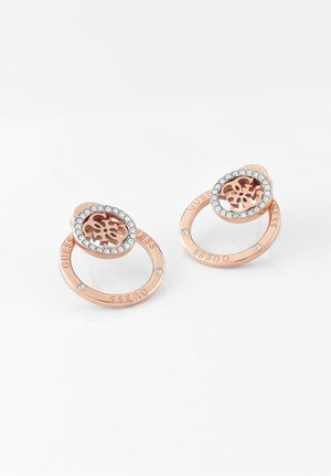 Rosa goldene kreisförmige Ohrringe mit eingebetteten Kristallen, mit ausgeschnittenem Blumenlogo und eingraviertem „GUESS“-Schriftzug am äußeren Ring.