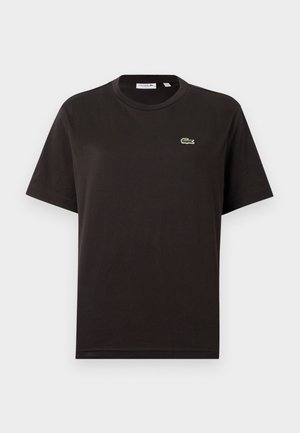 Svart bomulls t-skjorte med rund hals, korte ermer og liten grønn Lacoste-logo på venstre bryst. Myk tekstur, avslappet passform.