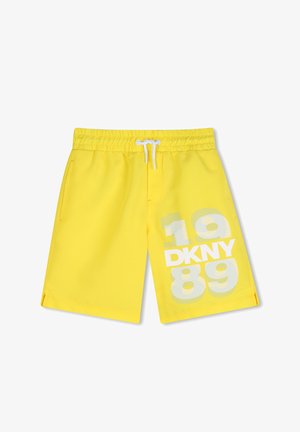 Yellow swim shorts with an elastic waistband and white drawstring. Features a gray graphic design with "DKNY" and the numbers "1989."