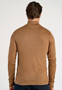 Brauner Strickpullover mit hohem Kragen und langen Ärmeln. Verfügt über gerippte Bündchen und Saum, eine glatte Textur und keine sichtbaren Muster oder Akzente.