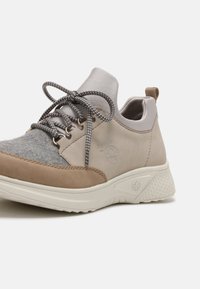 Sneakers with a combination of gray felt and beige leather, featuring metallic eyelets, gray laces, and a textured white sole.