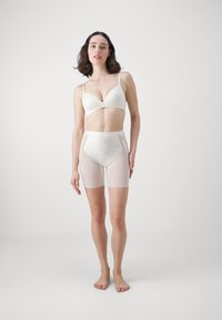 White bra with adjustable straps and soft cups, paired with high-waisted, sheer white shorts featuring smooth fabric and a fitted design.