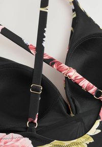Top bikini nero con spalline floreali nei colori rosa, bianco e verde. Include spalline regolabili e dettagli in metallo dorato. Tessuto testurizzato.