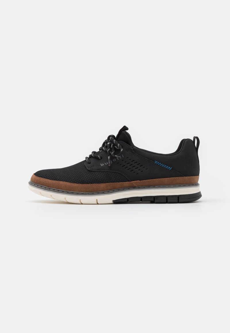 Fekete sneaker textúrált hálós felsőrésszel, barna bőr díszítéssel, kerek cipőfűzőkkel, és fehér-fekete talppal, amely tapadós mintázattal rendelkezik.