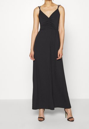 Robe maxi noire avec un décolleté en V, un buste froncé et de fines bretelles. Fabriquée en tissu doux, elle tombe élégamment jusqu'au sol.