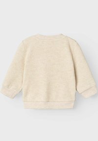 Maglione beige a coste con maniche lunghe, scollatura rotonda e orli a polsino. Caratterizzato da una consistenza morbida e un design semplice e minimalista.