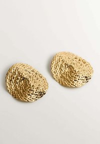 Pendientes tejidos en tono dorado con una superficie texturizada, que presentan una forma orgánica y redondeada y un diseño abierto.