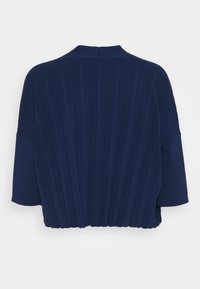 Dunkelblaues Strickoberteil mit gerippter Textur, runder Ausschnitt und weit geschnittenen Ärmeln, mit Raffung am Rücken für zusätzlichen Detail.