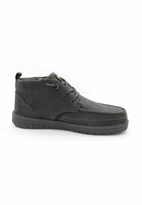 Stivali chukka in pelle nera con texture liscia, punta rotonda e lacci. Presentano un colletto imbottito e una suola in gomma per una buona aderenza.