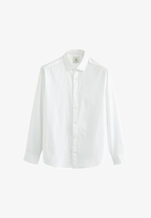 Bijela košulja dugih rukava s gumbima, meke teksture, klasičnog ovratnika i ravnim rubom. Ima gumbe sprijeda i oznaku na području vrata.