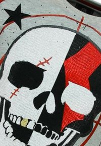 Grafisch T-shirt met een schedelontwerp in zwart, wit en rood, met stikdetails en een gestructureerde, lichtgrijze achtergrond.