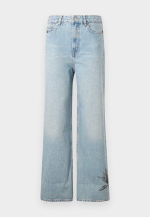 Light blue wide-leg jeans made of denim, featuring a faded texture and floral embroidery detail on the lower left leg.