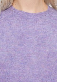 Pull en maille violet clair avec une texture douce, présentant un col rond et de subtiles variations de couleur. Design simple et classique.