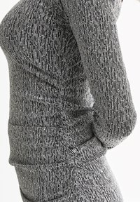 Tightly fitted black and silver sequined long-sleeve top and skirt worn by person, showing detailed shimmering texture and pattern.