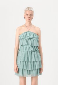 Bandeau miniklänning i mjukt mintgrönt tyg med lager av volanger, med en samlad halsringning och en lätt, genomskinlig textur.